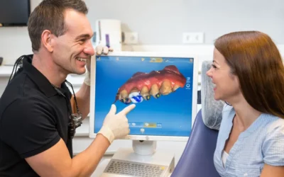 Dentist explaining CEREC same-day crown technology to a patient, showcasing a digital dental model on the screen.