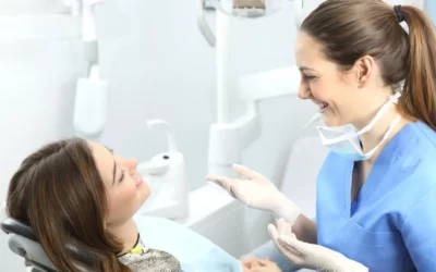 Dental hygienist discussing oral health with patient during teeth cleaning appointment.