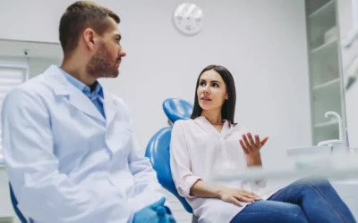 Patient discussing dental concerns with a dentist in a modern clinic setting, highlighting communication about oral health issues like bruxism.