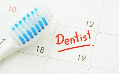 Toothbrush on calendar with "Dentist" marked, symbolizing the importance of scheduling dental appointments.