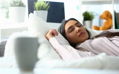 Woman sleeping peacefully on a couch, surrounded by soft pillows and a cozy environment, illustrating the importance of sleep in relation to sleep apnea treatment.